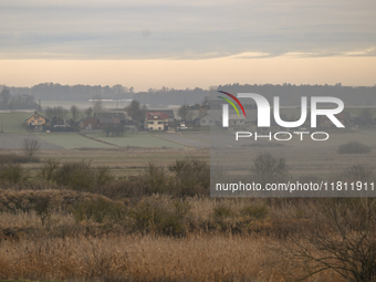 KRAKOW, POLAND - NOVEMBER 19:   
A small village with frozen fields and trees losing their leaves, seen from a train window as winter approa...