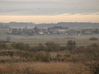 KRAKOW, POLAND - NOVEMBER 19:   
A small village with frozen fields and trees losing their leaves, seen from a train window as winter approa...