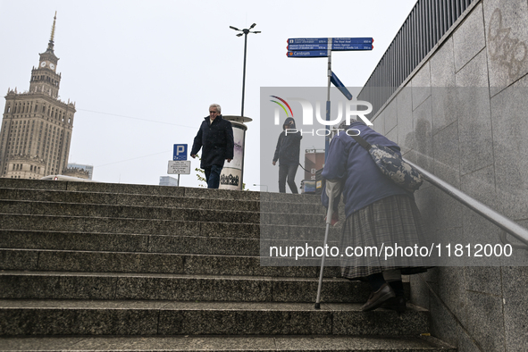 WARSAW, POLAND - NOVEMBER 19:   
An elderly lady walking up the stairs from an underground passage in front of Warsaw's Palace of Culture an...