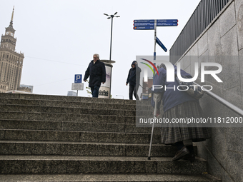 WARSAW, POLAND - NOVEMBER 19:   
An elderly lady walking up the stairs from an underground passage in front of Warsaw's Palace of Culture an...