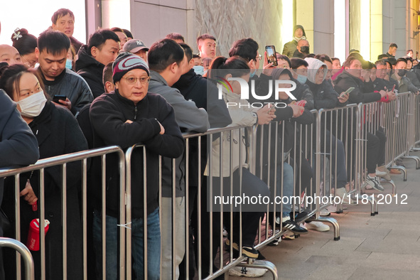 A large number of customers line up to buy new mobile phones outside Huawei's flagship store in Shanghai, China, on November 26, 2024. Some...