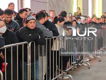 A large number of customers line up to buy new mobile phones outside Huawei's flagship store in Shanghai, China, on November 26, 2024. Some...