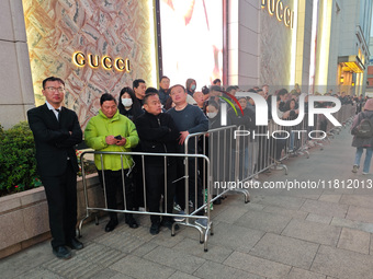 A large number of customers line up to buy new mobile phones outside Huawei's flagship store in Shanghai, China, on November 26, 2024. Some...