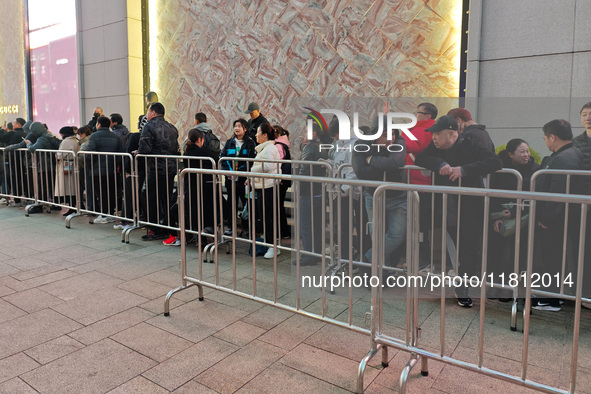 A large number of customers line up to buy new mobile phones outside Huawei's flagship store in Shanghai, China, on November 26, 2024. Some...