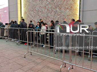 A large number of customers line up to buy new mobile phones outside Huawei's flagship store in Shanghai, China, on November 26, 2024. Some...