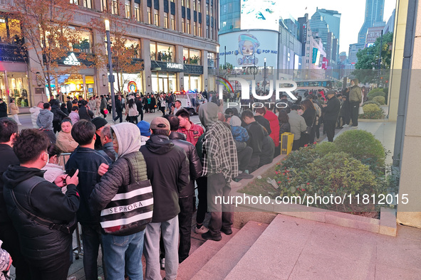 A large number of customers line up to buy new mobile phones outside Huawei's flagship store in Shanghai, China, on November 26, 2024. Some...