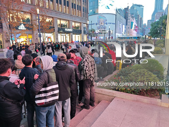 A large number of customers line up to buy new mobile phones outside Huawei's flagship store in Shanghai, China, on November 26, 2024. Some...