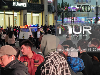 A large number of customers line up to buy new mobile phones outside Huawei's flagship store in Shanghai, China, on November 26, 2024. Some...