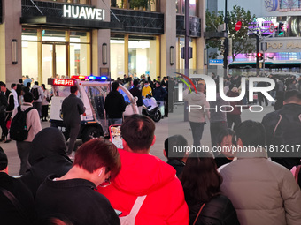 A large number of customers line up to buy new mobile phones outside Huawei's flagship store in Shanghai, China, on November 26, 2024. Some...