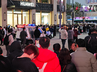 A large number of customers line up to buy new mobile phones outside Huawei's flagship store in Shanghai, China, on November 26, 2024. Some...