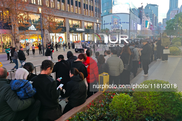 A large number of customers line up to buy new mobile phones outside Huawei's flagship store in Shanghai, China, on November 26, 2024. Some...