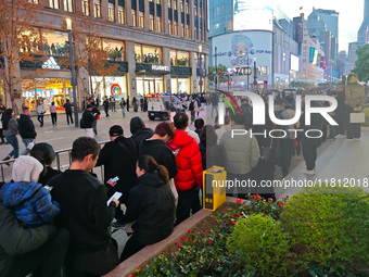 A large number of customers line up to buy new mobile phones outside Huawei's flagship store in Shanghai, China, on November 26, 2024. Some...