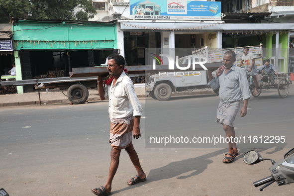 Labourers carry iron bars outside a shop at a steel and iron wholesale market in Kolkata, India, on November 26, 2024. In November 2024, Ind...