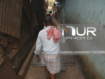 Labourers carry iron bars outside a shop at a steel and iron wholesale market in Kolkata, India, on November 26, 2024. In November 2024, Ind...