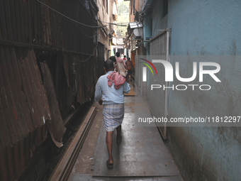 Labourers carry iron bars outside a shop at a steel and iron wholesale market in Kolkata, India, on November 26, 2024. In November 2024, Ind...