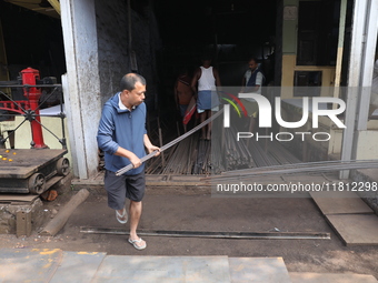 Labourers carry iron rods outside a shop at a steel and iron wholesale market in Kolkata, India, on November 26, 2024. In November 2024, Ind...