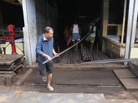 Labourers carry iron rods outside a shop at a steel and iron wholesale market in Kolkata, India, on November 26, 2024. In November 2024, Ind...