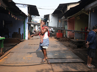 A laborer carries iron rods outside a shop at a steel and iron wholesale market in Kolkata, India, on November 26, 2024. In November 2024, I...