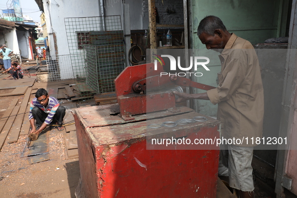 Labourers work with iron outside a shop at a steel and iron wholesale market in Kolkata, India, on November 26, 2024. In November 2024, Indi...