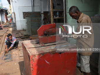 Labourers work with iron outside a shop at a steel and iron wholesale market in Kolkata, India, on November 26, 2024. In November 2024, Indi...