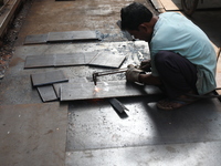 A laborer cuts an iron plate outside a shop at a steel and iron wholesale market in Kolkata, India, on November 26, 2024. In November 2024,...