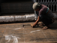 A laborer cuts an iron plate outside a shop at a steel and iron wholesale market in Kolkata, India, on November 26, 2024. In November 2024,...