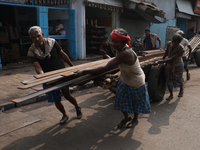 Labourers pull a handcart loaded with iron rods to a road construction site at a steel and iron wholesale market in Kolkata, India, on Novem...