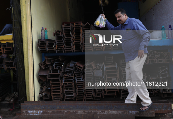 A trader comes out from his shop at a wholesale steel and iron market in Kolkata, India, on November 26, 2024. In November 2024, India's dom...