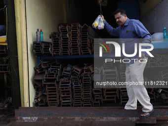 A trader comes out from his shop at a wholesale steel and iron market in Kolkata, India, on November 26, 2024. In November 2024, India's dom...