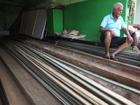 A trader sits inside his shop beside a dog at a wholesale steel and iron market in Kolkata, India, on November 26, 2024. In November 2024, I...