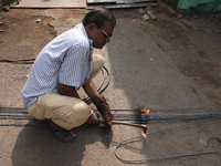 A laborer cuts an iron plate outside a shop at a steel and iron wholesale market in Kolkata, India, on November 26, 2024. In November 2024,...