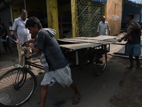 Labourers pull a cycle rickshaw loaded with iron plates at a wholesale iron market in Kolkata, India, on November 26, 2024. In November 2024...