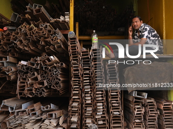 A trader speaks on his mobile phone inside his shop at a wholesale steel and iron market in Kolkata, India, on November 26, 2024. In Novembe...