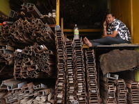 A trader speaks on his mobile phone inside his shop at a wholesale steel and iron market in Kolkata, India, on November 26, 2024. In Novembe...