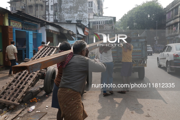 Labourers carry iron bars to load onto a truck at a steel and iron wholesale market in Kolkata, India, on November 26, 2024. In November 202...