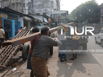 Labourers carry iron bars to load onto a truck at a steel and iron wholesale market in Kolkata, India, on November 26, 2024. In November 202...