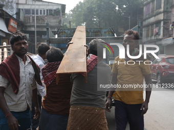 Labourers carry iron bars to load onto a truck at a steel and iron wholesale market in Kolkata, India, on November 26, 2024. In November 202...