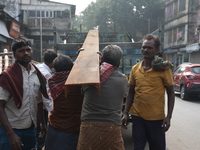 Labourers carry iron bars to load onto a truck at a steel and iron wholesale market in Kolkata, India, on November 26, 2024. In November 202...