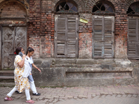 A woman speaks on her mobile phone as she walks past an abandoned temple near a steel and iron wholesale market in Kolkata, India, on Novemb...