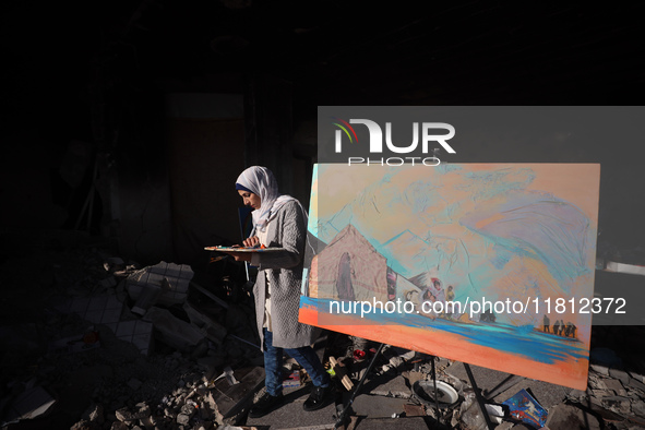 Palestinian artist Maysaa Youssef, 38, paints amidst the rubble of her home, which is destroyed by Israeli shelling in Deir al-Balah, on Nov...