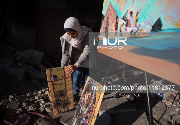 Palestinian artist Maysaa Youssef, 38, paints amidst the rubble of her home, which is destroyed by Israeli shelling in Deir al-Balah, on Nov...