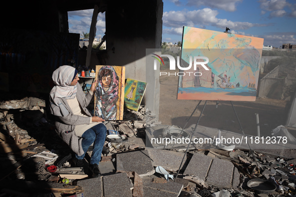 Palestinian artist Maysaa Youssef, 38, paints amidst the rubble of her home, which is destroyed by Israeli shelling in Deir al-Balah, on Nov...