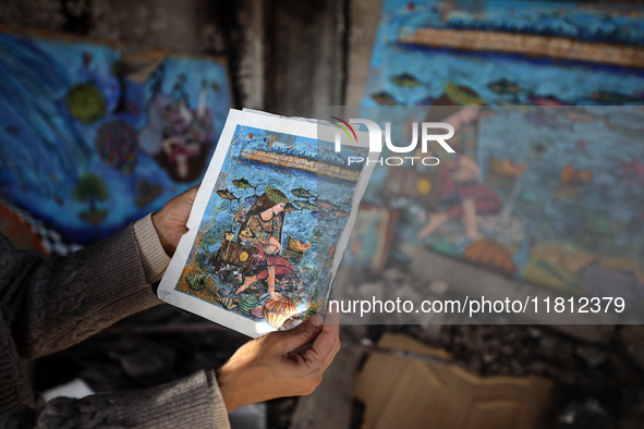 Palestinian artist Maysaa Youssef, 38, paints amidst the rubble of her home, which is destroyed by Israeli shelling in Deir al-Balah, on Nov...