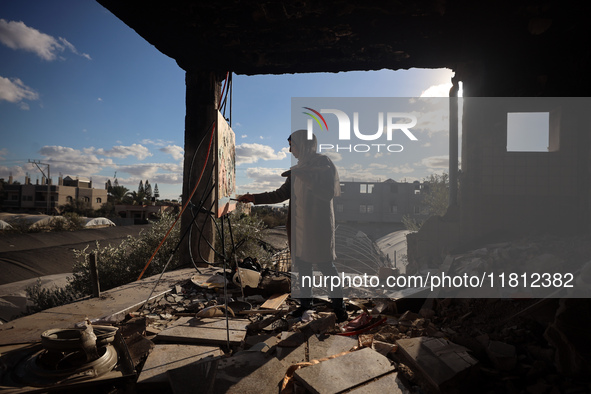 Palestinian artist Maysaa Youssef, 38, paints amidst the rubble of her home, which is destroyed by Israeli shelling in Deir al-Balah, on Nov...