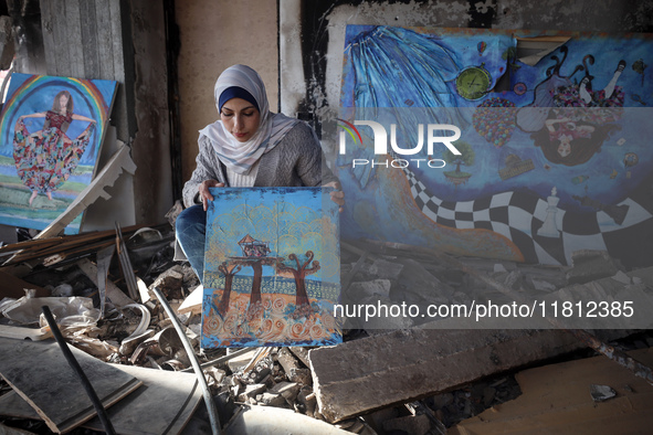 Palestinian artist Maysaa Youssef, 38, paints amidst the rubble of her home, which is destroyed by Israeli shelling in Deir al-Balah, on Nov...