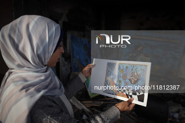 Palestinian artist Maysaa Youssef, 38, paints amidst the rubble of her home, which is destroyed by Israeli shelling in Deir al-Balah, on Nov...