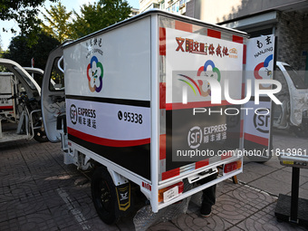 An express delivery vehicle is at the gate of an SF Express station in Nanjing, China, on November 27, 2024. (