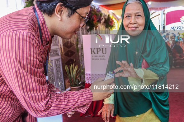 People participate in the simultaneous regional election at a polling station in Semarang, Central Java Province, on November 27, 2024. Indo...