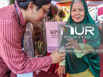 People participate in the simultaneous regional election at a polling station in Semarang, Central Java Province, on November 27, 2024. Indo...