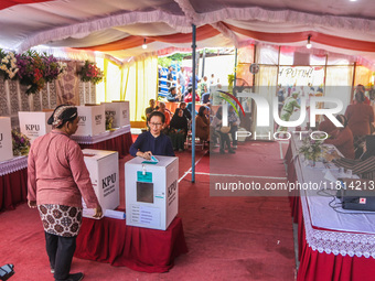 People participate in the simultaneous regional election at a polling station in Semarang, Central Java Province, on November 27, 2024. Indo...